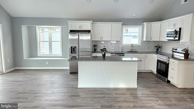 kitchen featuring white cabinetry, sink, a kitchen island, and appliances with stainless steel finishes