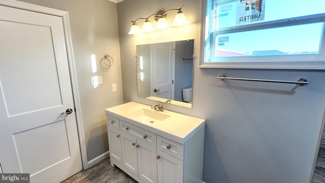 bathroom with vanity, hardwood / wood-style flooring, and toilet