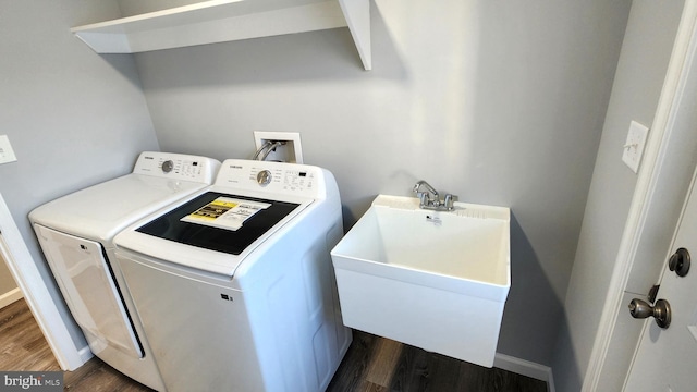 laundry room with dark wood-type flooring, separate washer and dryer, and sink