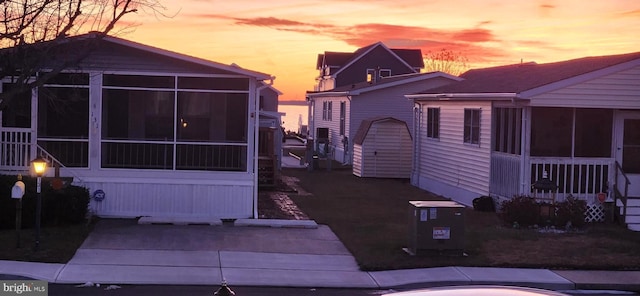 property exterior at dusk featuring central AC unit and a sunroom