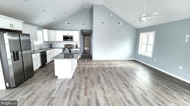 kitchen featuring sink, dark stone countertops, appliances with stainless steel finishes, white cabinets, and backsplash