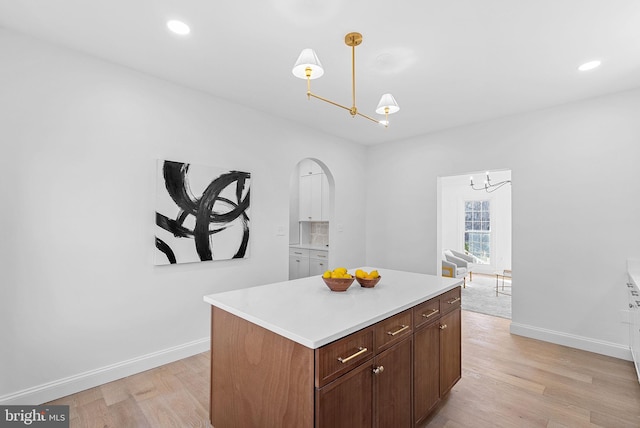 kitchen featuring a center island, light hardwood / wood-style floors, and decorative light fixtures