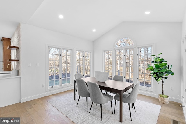 dining area with plenty of natural light, vaulted ceiling, and light wood-type flooring