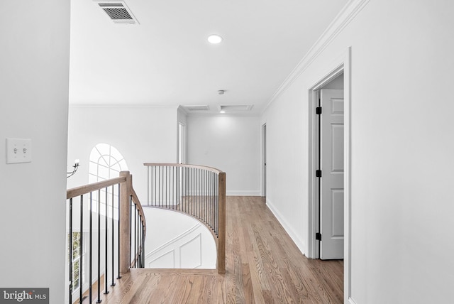 corridor featuring crown molding, a wealth of natural light, and light hardwood / wood-style floors