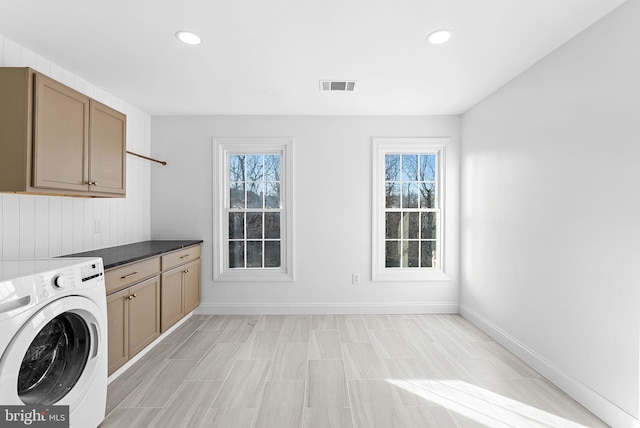 laundry area featuring washer / clothes dryer, a healthy amount of sunlight, and cabinets