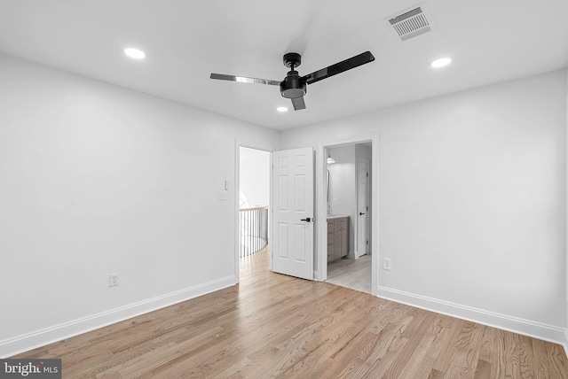 unfurnished bedroom featuring ceiling fan, ensuite bathroom, and light wood-type flooring