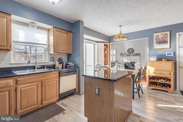 kitchen featuring sink, a center island, a textured ceiling, and dishwasher