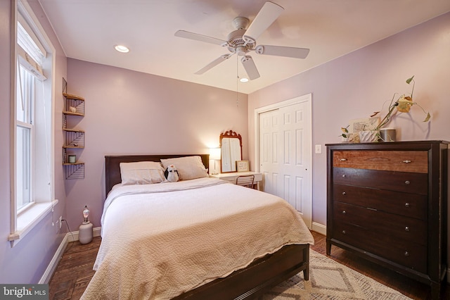 bedroom with ceiling fan, dark wood-type flooring, and a closet