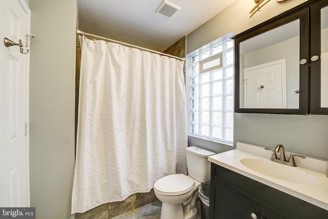 bathroom featuring toilet, a wealth of natural light, and vanity