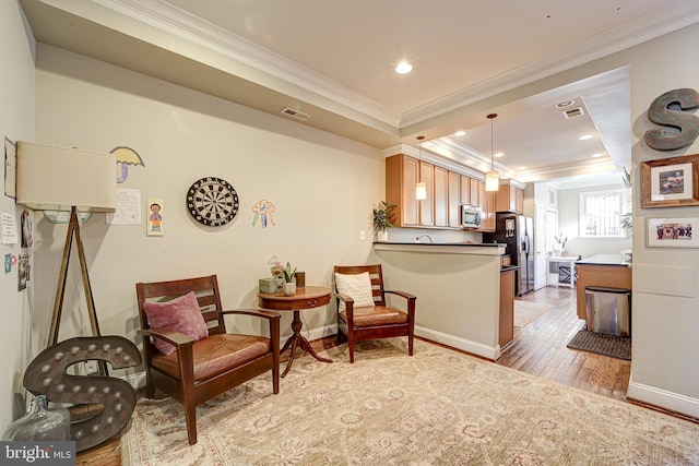 sitting room featuring ornamental molding and light hardwood / wood-style floors