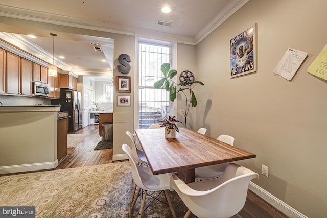 dining area featuring dark hardwood / wood-style flooring and ornamental molding