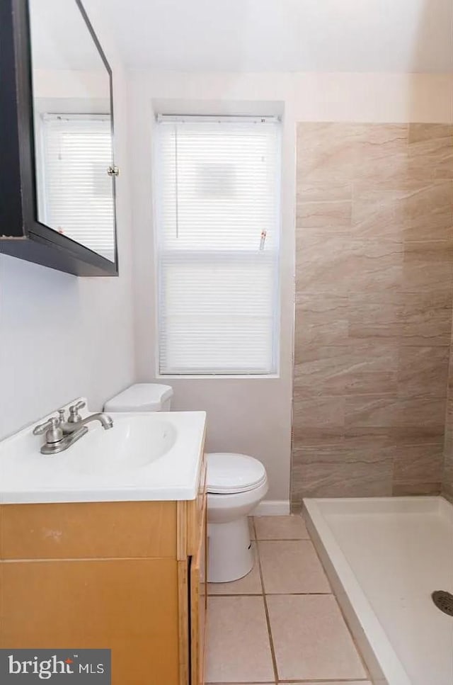 bathroom with walk in shower, vanity, toilet, and tile patterned flooring