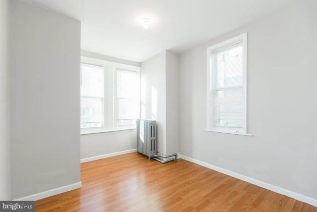 spare room with radiator and hardwood / wood-style floors