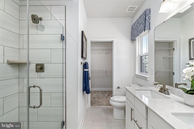 bathroom with vanity, toilet, an enclosed shower, and tile patterned flooring