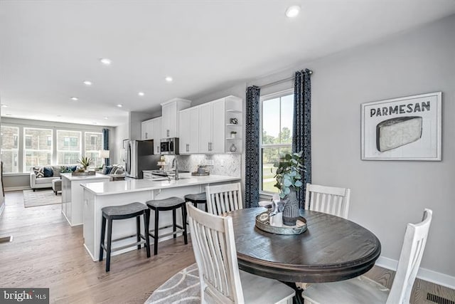 dining space with plenty of natural light, light hardwood / wood-style flooring, and sink