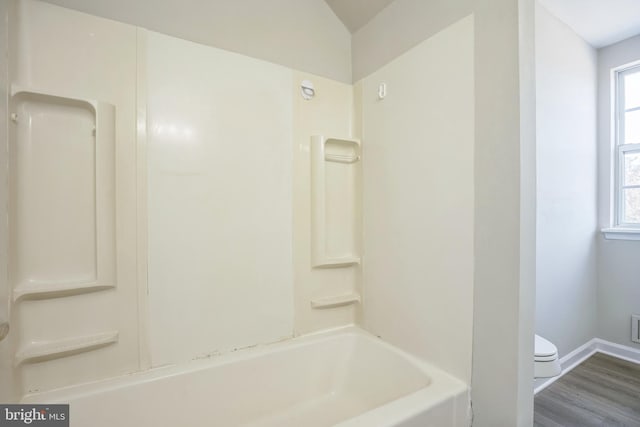 bathroom featuring toilet, shower / tub combination, and wood-type flooring