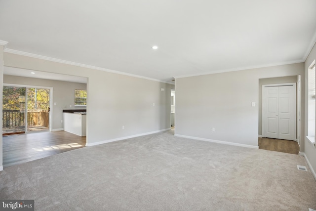 empty room featuring light colored carpet and crown molding