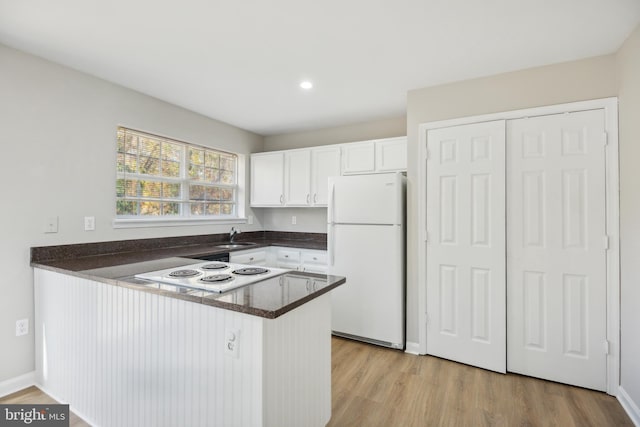 kitchen with kitchen peninsula, light hardwood / wood-style flooring, sink, white cabinetry, and white appliances