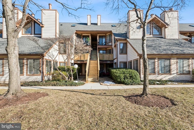 exterior space featuring a shingled roof, a chimney, and a balcony