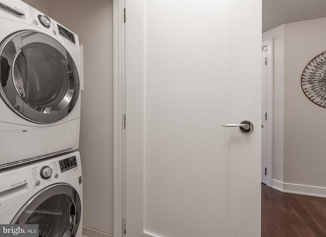 washroom featuring dark hardwood / wood-style flooring and stacked washer and clothes dryer