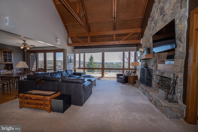 carpeted living room with wooden ceiling, a fireplace, a wealth of natural light, and a high ceiling