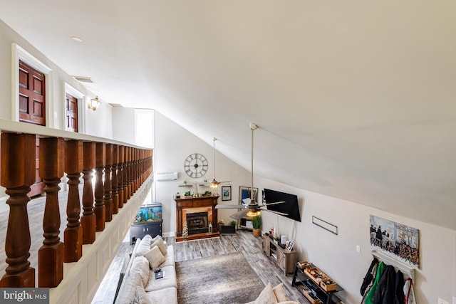 living room featuring ceiling fan, wood-type flooring, and lofted ceiling