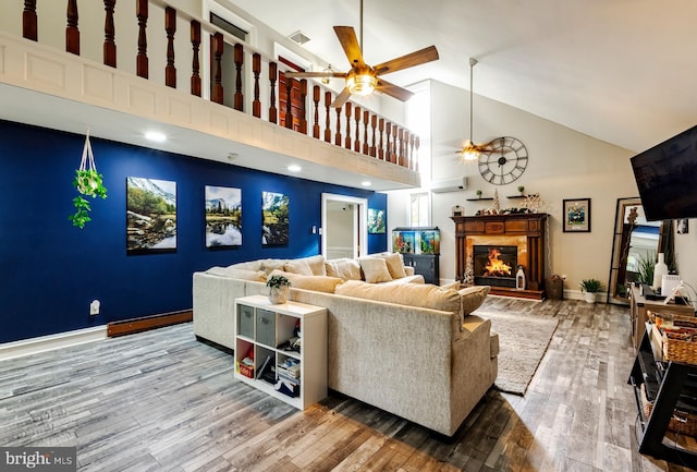 living room featuring wood-type flooring, a baseboard radiator, high vaulted ceiling, and ceiling fan