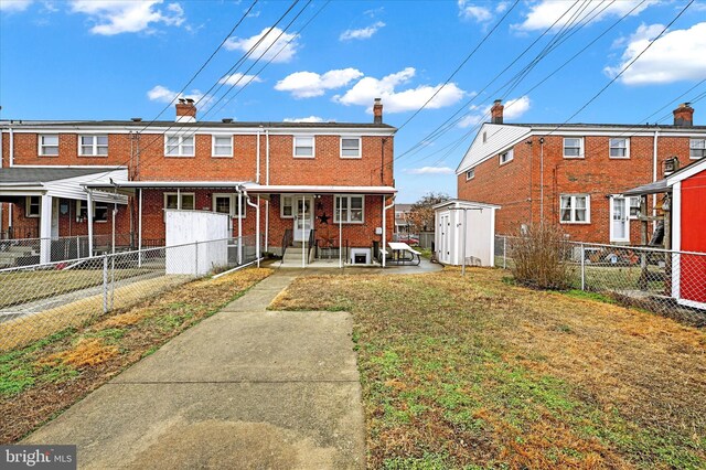 rear view of property with a yard and a storage shed