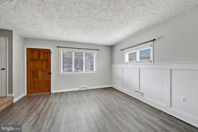 unfurnished room featuring hardwood / wood-style flooring and a textured ceiling