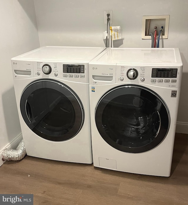 laundry area with hardwood / wood-style flooring and independent washer and dryer