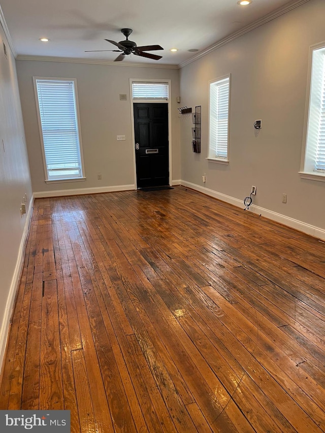 interior space with dark wood-type flooring, ornamental molding, and a healthy amount of sunlight