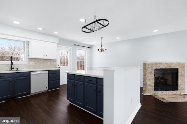 kitchen with sink, dishwasher, pendant lighting, a healthy amount of sunlight, and white cabinets