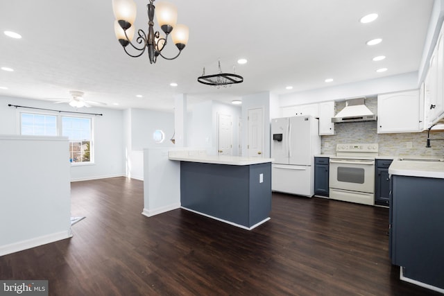 kitchen with white cabinets, white appliances, decorative light fixtures, and wall chimney exhaust hood