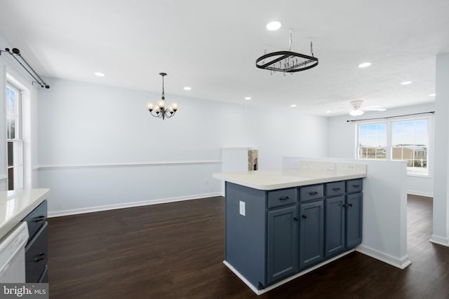 kitchen with dark hardwood / wood-style floors, ceiling fan with notable chandelier, hanging light fixtures, and white dishwasher