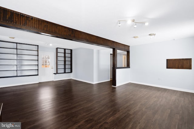 unfurnished living room featuring dark wood-type flooring and built in shelves