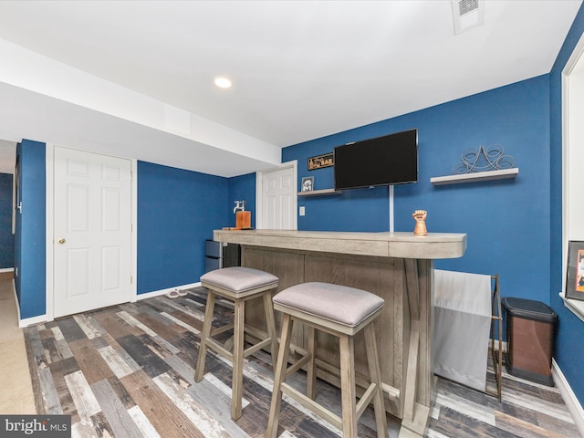 bar with dark hardwood / wood-style flooring