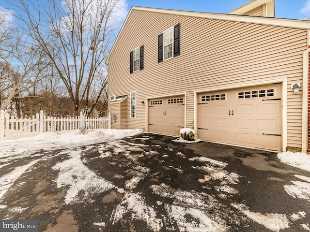 view of snowy exterior featuring a garage