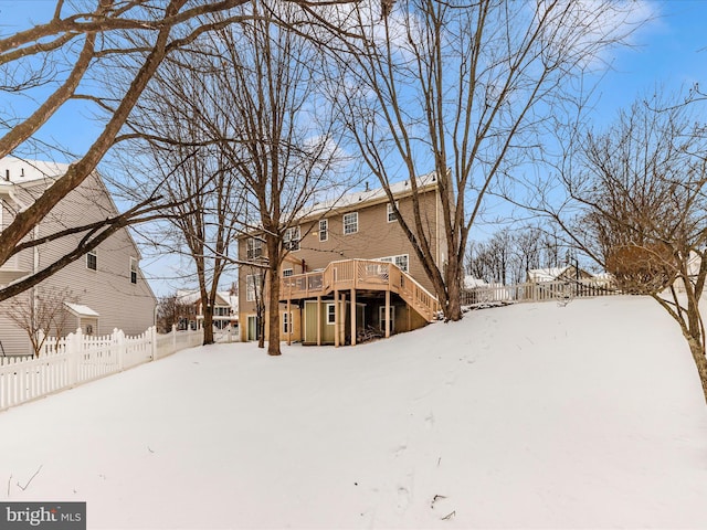 snow covered rear of property featuring a deck