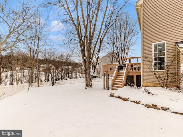 yard layered in snow featuring a wooden deck