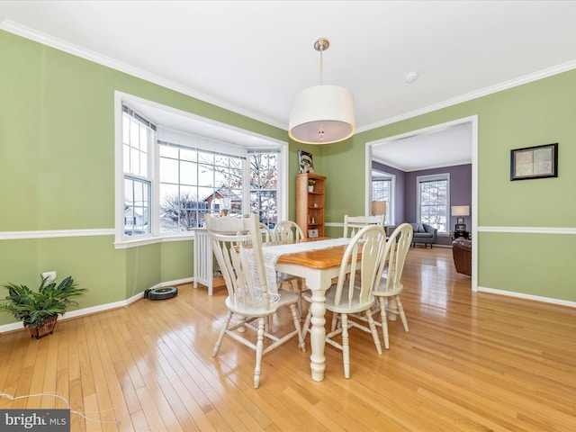 dining area with light hardwood / wood-style flooring and crown molding