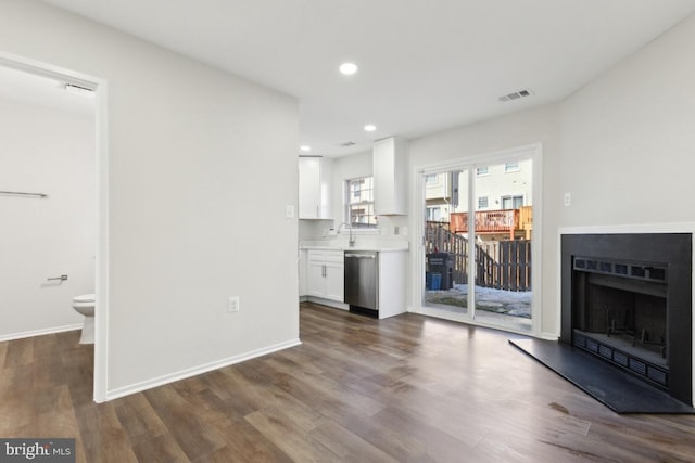 unfurnished living room featuring dark wood-type flooring and sink