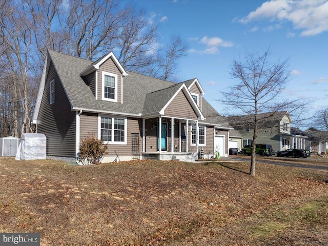 new england style home featuring a garage and a porch