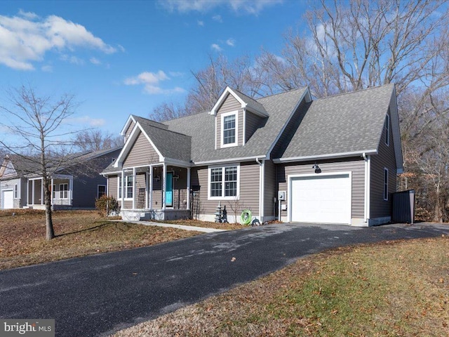 cape cod home featuring a porch and a garage