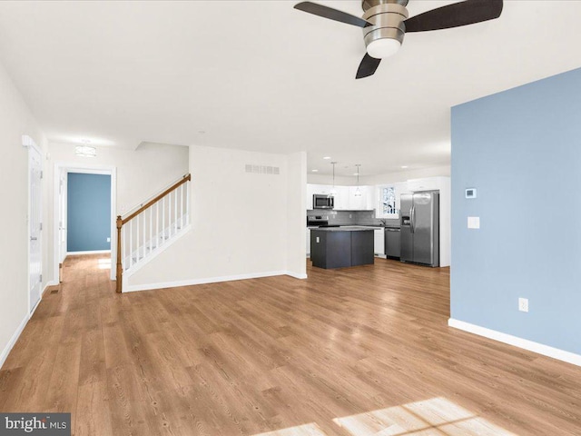 unfurnished living room with ceiling fan and light hardwood / wood-style flooring