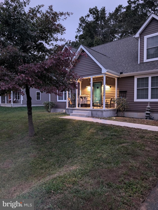 view of front of property featuring covered porch and a lawn