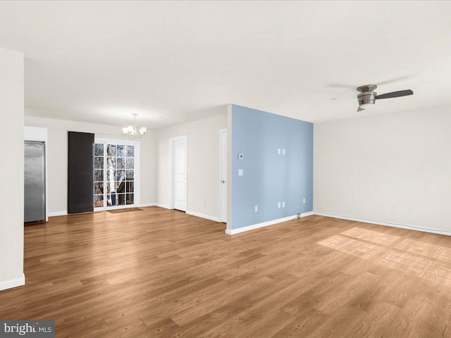 unfurnished living room with hardwood / wood-style flooring and ceiling fan with notable chandelier