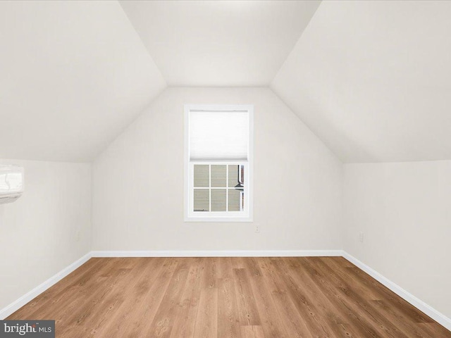 bonus room with vaulted ceiling and light wood-type flooring