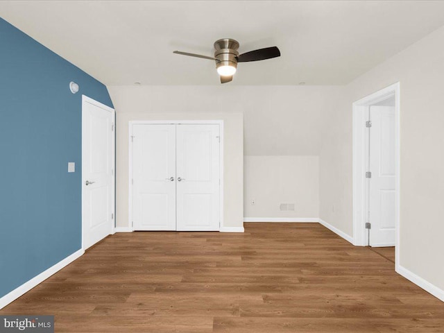 unfurnished bedroom with hardwood / wood-style floors, a closet, and ceiling fan