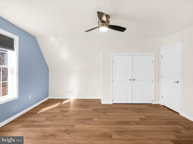 additional living space with wood-type flooring, vaulted ceiling, and ceiling fan