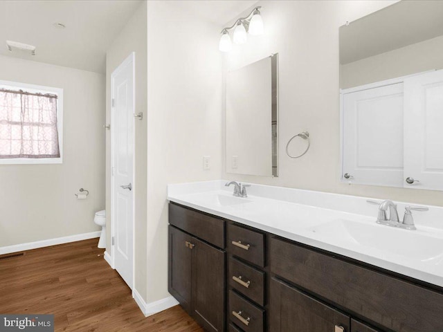 bathroom with vanity, hardwood / wood-style flooring, and toilet